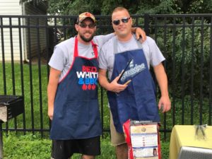 Two Timber Grove teachers in aprons manning the grill