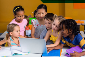 Diverse group of six children staring at a laptop computer.