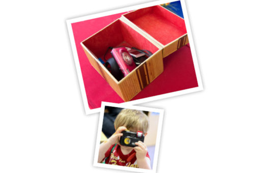 Photos in frames, including a box with camera supplies and a little boy taking a picture.