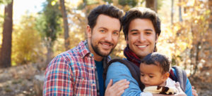Male Couple With Baby Walking Through Fall Woodland