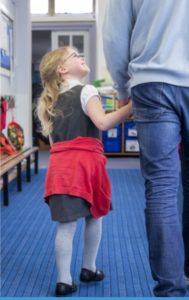 Gentle Transition Tips for parents of young children - ayoung girl holds her parent's hand and looks up to them as they walk into a classroom