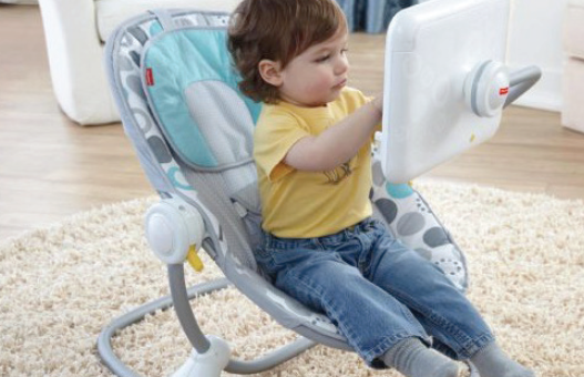 A young child sits in a bouncy sit equipped with an age-appropriate activity screen.