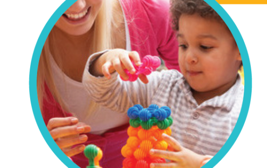 A little boy plays with math toys with his teacher.