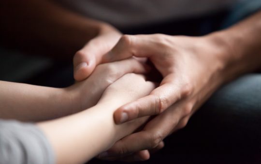 picture of adult hands holding hands of child