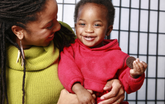 African American woman holding toddler boy on her lap