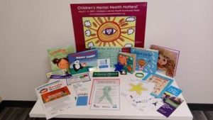 A display table holds resources for children's mental health awareness week.