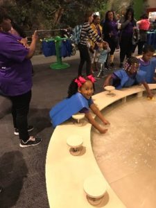 A girl plays in a water exhibit at a children's museum