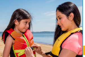 Mother helps girl with her life jacket