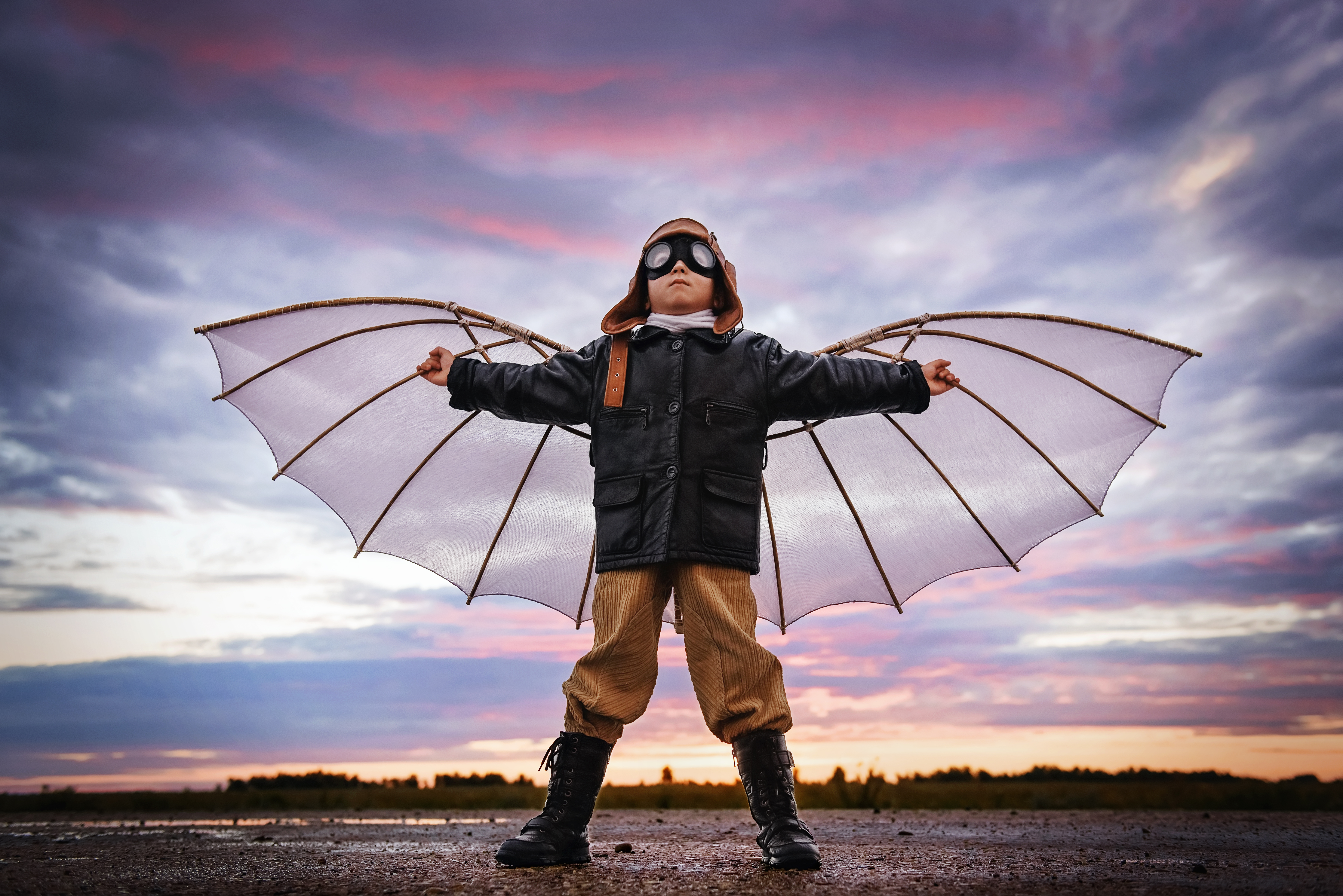 boy dressed in aviator gear with wings