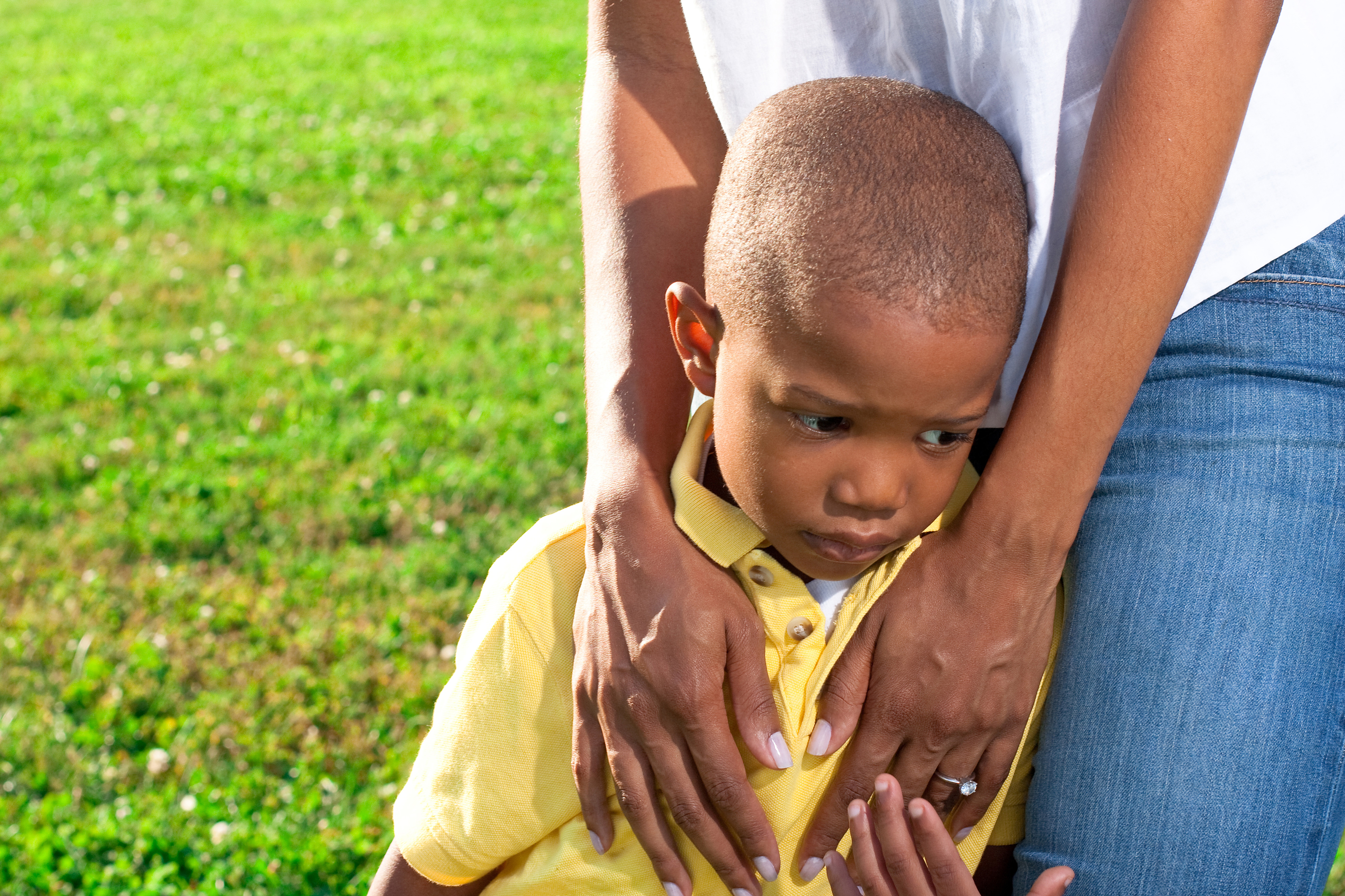 a young african american boy is comforted by his mom