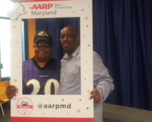 Grandparents holding AARP Maryland photo border.