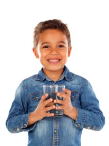 Little boy wearing a jean jacket holding a cup of water.
