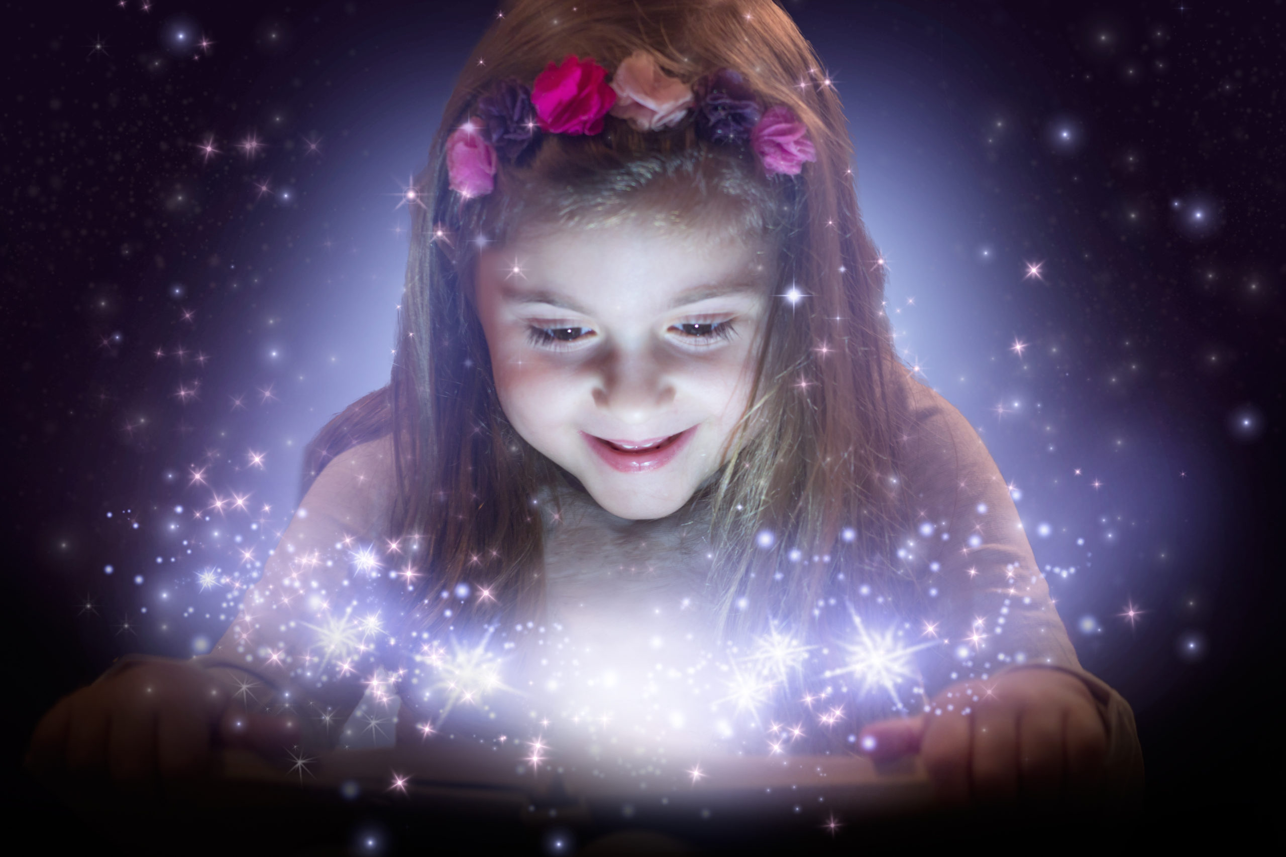 Little girl reading magic book; fantasy concept